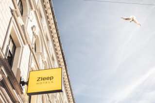 A Zleep Hotel sign on the facade of an historic building.