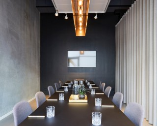 A contemporary conference room, furnished in different shades of grey.