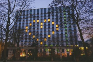 A modern, illuminated building at night.