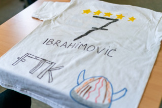 A T-shirt that a child has transformed into a homemade soccer jersey with markers.